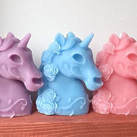 unicorn skull candles with flowers in their mane